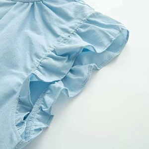 Detail of light blue shirt featuring ruffled flutter sleeves and neat stitching