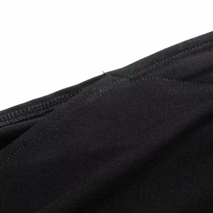 Detail shot of the black knit dress showing precise double-needle stitching on the hemline