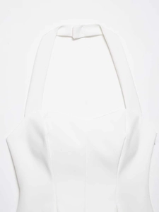 Detailed view of white halter neck top featuring textured fabric and clean finish
