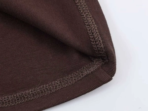 Detailed macro view of the brown ribbed knit hem with professional double-needle stitching