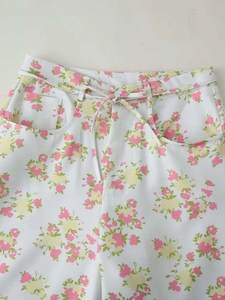 Detailed view of floral wide-leg pants with drawstring waist and pastel pattern prints