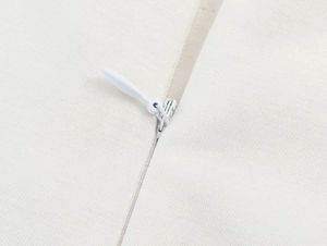 Detail of invisible zipper closure on the minimalist cream sleeveless summer dress