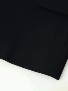 Vue détaillée de la texture du tissu sergé noir avec des finitions de couture fines