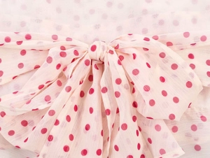 Close-up of pink georgette halter top featuring red polka dots and soft bow detail