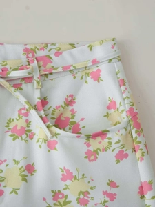 Detailed view of floral print trousers with belt loops, slim belt and side pockets