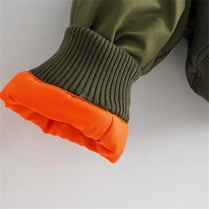Detail of army green flight jacket showing ribbed cuffs and contrast orange lining