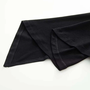 Detailed close-up of double-stitched hem on high-quality black knit dress fabric
