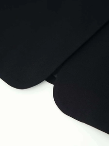 Gros plan de l'ourlet du blazer noir montrant la texture fine du tissu en sergé