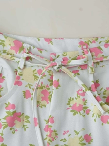 Detailed view of floral print waistline with matching fabric belt and white button
