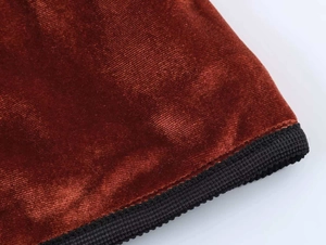 Detailed macro view of the brown velvet fabric and black ribbed cuff on the jacket