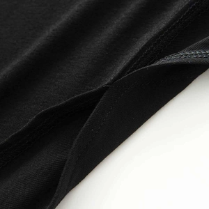 Detailed macro view of black knitted fabric stitching and irregular hemline seam