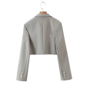 Detail of grey blazer sleeve with four decorative buttons and smooth fabric texture