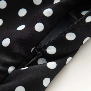 Detailansicht eines schwarz-weißen Punktkleides mit unsichtbarem Reißverschluss