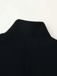 Détail du col montant et de la texture du tissu de qualité supérieure sur le blazer noir