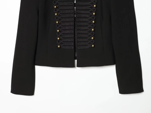 Detail of black military jacket with gold buttons and braided frogging on blazer