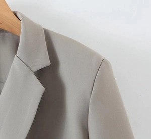 Close-up of grey notched lapel blazer featuring detailed twill fabric and shoulder stitching