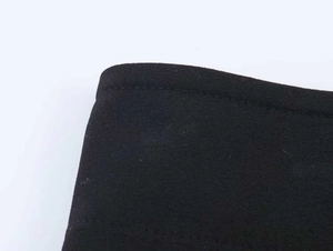 Detailed view of double-needle flat stitching on black knit fabric with smooth texture