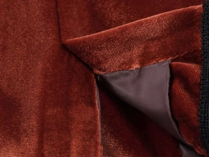 Detailed close-up of premium red velvet fabric texture with elegant black lace trim