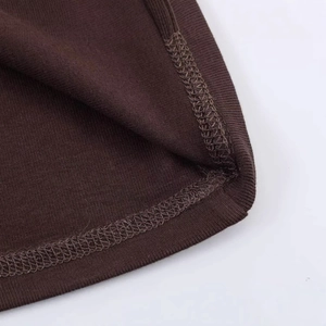 Close-up of deep brown ribbed knit fabric with professional overlock stitching detail