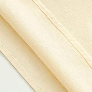 Close-up of beige fabric texture with high-quality stitching and plain weave details