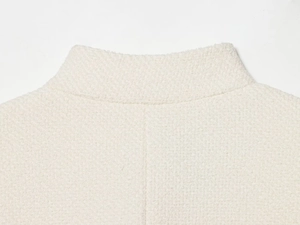 Gros plan détaillé de la veste crème en coton mélangé avec col montant minimaliste