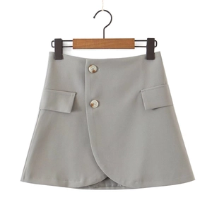 Detail of gray wrap mini skirt featuring decorative round buttons and flap pockets