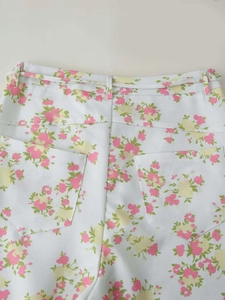 Detail of floral wide leg pants featuring back pockets and belt loops on woven fabric