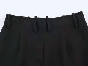 Detail of high waist black suit trousers showing wide belt loops and premium stitching