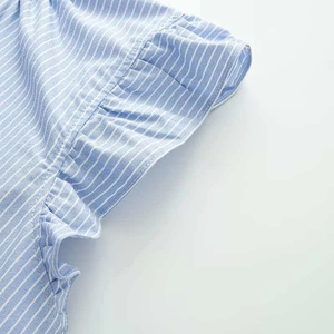 Close-up of ruffled cap sleeve on light blue and white striped shirt for women