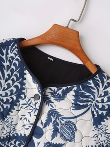 Close-up of quilted floral jacket neckline with blue plant print and size S label