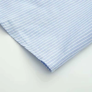 Macro detail of blue and white striped fabric with neat stitching on frill sleeve shirt