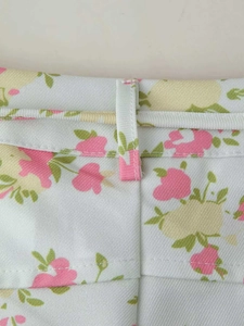 Detail of floral wide-leg trousers showing waistband stitching and fabric texture