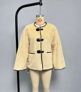 Détail du manteau en fausse fourrure avec passepoil en cuir contrasté et boutons