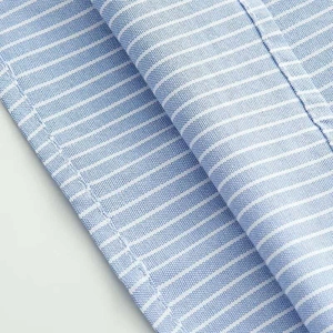 Detail of blue and white striped shirt fabric with fine stitching and Oxford texture