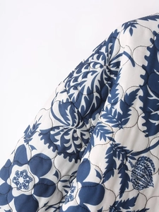 Detailed macro view of quilted floral fabric with wavy stitching on padded jacket