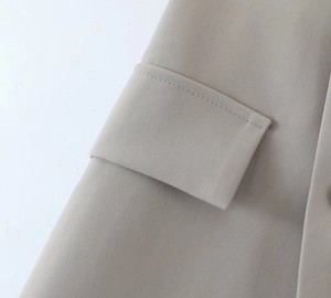 Detail shot of the khaki blazer featuring a flap pocket and high-quality twill fabric texture