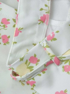 Detail of floral fabric with pink petals, green leaves, and high-quality stitching seams