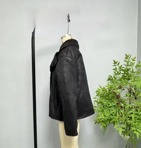 Detail view of the sleeve and side tailoring on a black faux suede shearling jacket