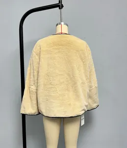 Vue arrière d'une veste en fausse fourrure crème avec passepoil noir et texture pelucheuse