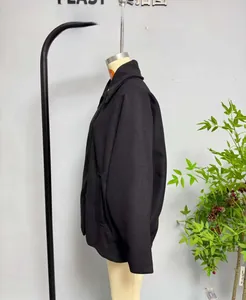 Side view detail of a black wool blend jacket featuring a stand collar and side pockets