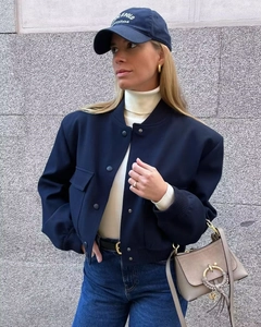Urban style navy bomber jacket with drop shoulders and large pockets in outdoor setting