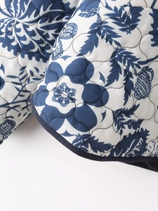 Detailed close-up of quilted floral pattern fabric with navy blue trim and high-quality stitching