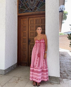 Detail of pink and red bohemian crochet maxi dress with tassels and ethnic patterns