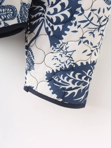 Detail shot of navy blue floral print quilted jacket cuff with fine stitched binding