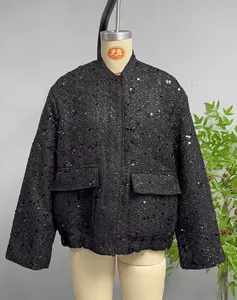 Detail of a black sequined tweed jacket with flap pockets and standing collar style