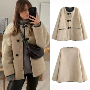 Veste chic en fausse fourrure beige avec col rond et brandebourgs noirs boutonnés