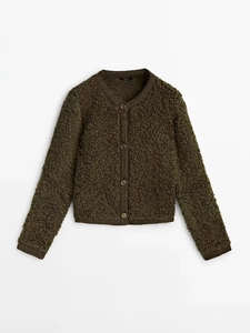 Detail of olive green textured boucle knit cardigan with four classic round buttons