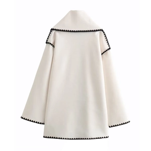 Back view of ivory wool coat featuring black wavy scalloped edges and oversized collar