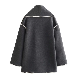 Detail view of the dark grey wool jacket with elegant white scalloped edge trim