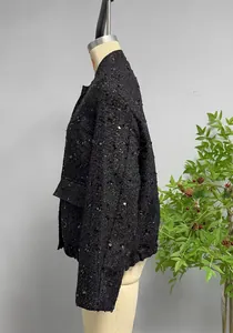 Detail of black sequined tweed jacket showing rich texture and shimmering round sequins